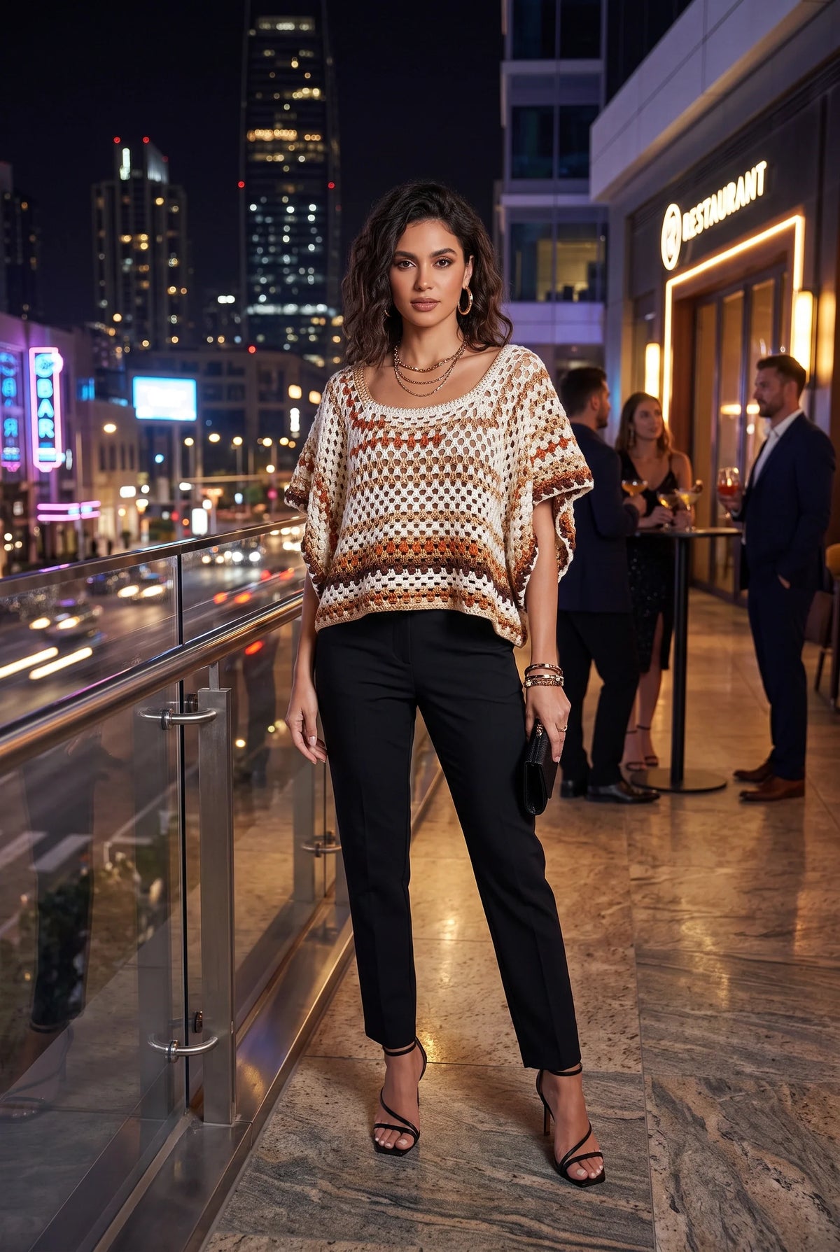 Model wearing the Desert Stripe Crochet Short-Sleeve Top with black trousers on a city rooftop at night